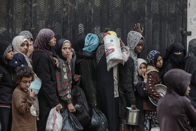 Palestinians gather to receive food cooked by a charity kitchen amid a hunger crisis as the Israel-Gaza-stock-foto