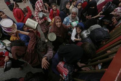 Palestinians gather to receive food cooked by a charity kitchen amid a hunger crisis as the Israel-Gaza-stock-foto