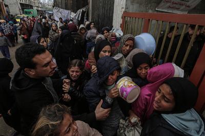 Palestinians gather to receive food cooked by a charity kitchen amid a hunger crisis as the Israel-Gaza-stock-foto