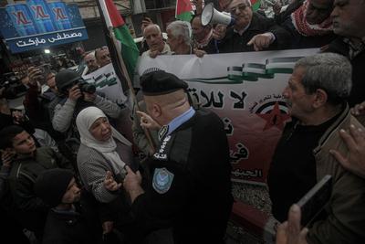Palestinians police officers attempts to disperse demonstrators during a protest against clashes between Palestinian security forces-stock-foto