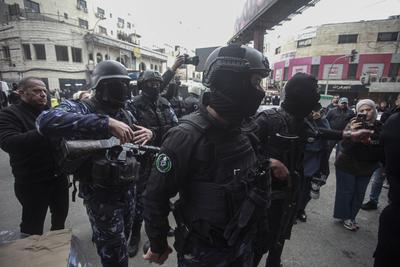 Palestinians police officers attempts to disperse demonstrators during a protest against clashes between Palestinian security forces-stock-foto