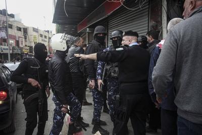 Palestinians police officers attempts to disperse demonstrators during a protest against clashes between Palestinian security forces-stock-foto