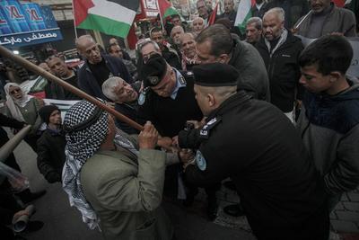 Palestinians police officers attempts to disperse demonstrators during a protest against clashes between Palestinian security forces-stock-foto