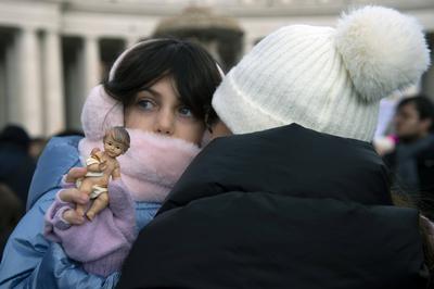 ITALY -  PEOPLE HOLD STATUETTES OF BABY JESUS IN ST PETER'S SQUARE AT  THE VATICAN  - 2024/12/22-stock-photo