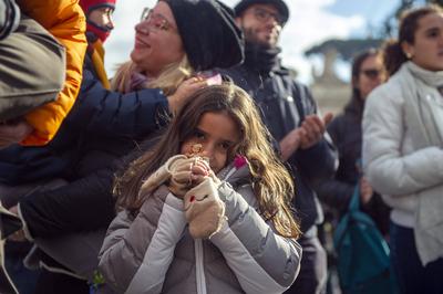 ITALY -  PEOPLE HOLD STATUETTES OF BABY JESUS IN ST PETER'S SQUARE AT  THE VATICAN  - 2024/12/22-stock-photo