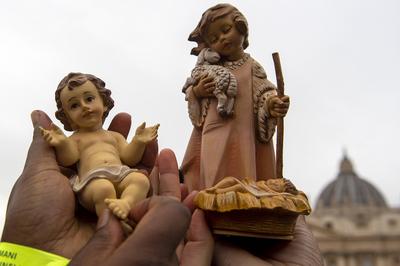 ITALY -  PEOPLE HOLD STATUETTES OF BABY JESUS IN ST PETER'S SQUARE AT  THE VATICAN  - 2024/12/22-stock-photo