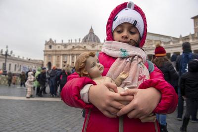 ITALY -  PEOPLE HOLD STATUETTES OF BABY JESUS IN ST PETER'S SQUARE AT  THE VATICAN  - 2024/12/22-stock-photo