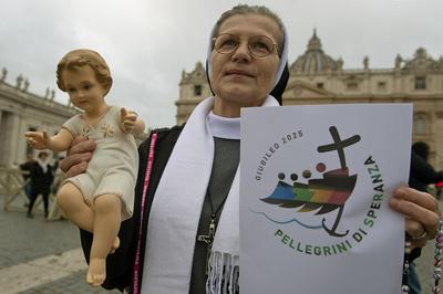ITALY -  PEOPLE HOLD STATUETTES OF BABY JESUS IN ST PETER'S SQUARE AT  THE VATICAN  - 2024/12/22-stock-photo