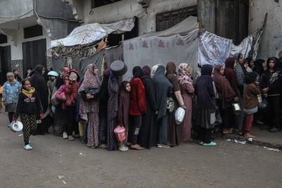 Palestinians gather to receive food cooked by a charity kitchen amid a hunger crisis as the Israel-Gaza-stock-foto