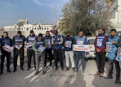 Journalists hold placards as they gather outside the Al Ahli Baptist Hospital in Gaza City to commemorate five colleagues who lost their lives in Israeli attacks on Gaza-stock-foto