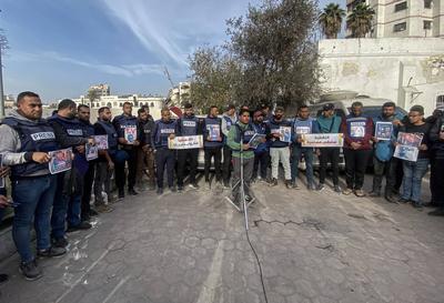 Journalists hold placards as they gather outside the Al Ahli Baptist Hospital in Gaza City to commemorate five colleagues who lost their lives in Israeli attacks on Gaza-stock-foto