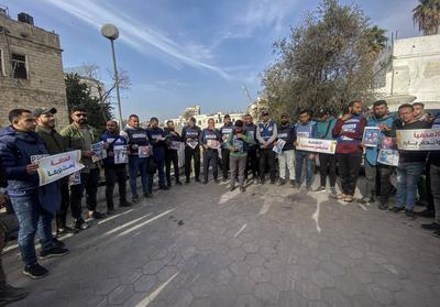 Journalists hold placards as they gather outside the Al Ahli Baptist Hospital in Gaza City to commemorate five colleagues who lost their lives in Israeli attacks on Gaza-stock-foto