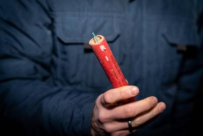 Kammlach, Bavaria, Germany - December 31, 2023: Man holding a large firecracker outdoors on New Year s Eve *** Mann h?lt-stock-foto