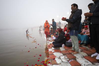 A holy man help pilgrim to offer prayer at the bank of Sangam (confluence of rive Ganga, Yamuna, and mythical Saraswati)-stock-foto