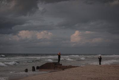 Palestinians walk on the beach during sunset on the last day of 2024 in Deir al-Balah in the central Gaza Strip, on 31 December 2024. Heavy rains in the Gaza-stock-foto