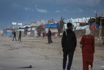 Palestinians walk on the beach during sunset on the last day of 2024 in Deir al-Balah in the central Gaza Strip, on 31 December 2024. Heavy rains in the Gaza-stock-foto