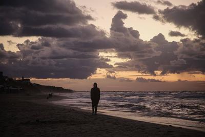 Palestinians walk on the beach during sunset on the last day of 2024 in Deir al-Balah in the central Gaza Strip, on 31 December 2024. Heavy rains in the Gaza-stock-foto