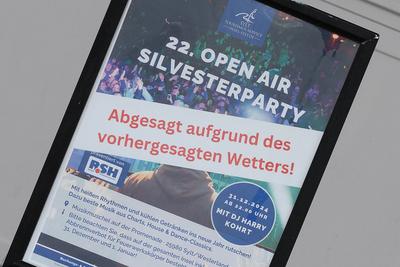 31.12.2024, Westerland --- Ein Schild Silvesterparty - Abgesagt aufrund des vorhergesagten Wetters! steht in der Musikmu-stock-foto