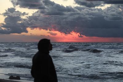 Palestinians walk on the beach during sunset on the last day of 2024 in Deir al-Balah in the central Gaza Strip, on 31 December 2024. Heavy rains in the Gaza-stock-foto