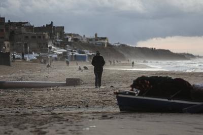 Palestinians walk on the beach during sunset on the last day of 2024 in Deir al-Balah in the central Gaza Strip, on 31 December 2024. Heavy rains in the Gaza-stock-foto