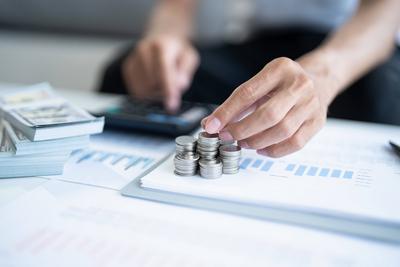 Geld sparen. Mann berechnen Finanzen nach Hause zahlen Rechnungen Steuern Einsparungen Wirtschaft finanzielle zu Hause und Geld stapeln M?nzen mit Taschenrechner sparen-stock-foto