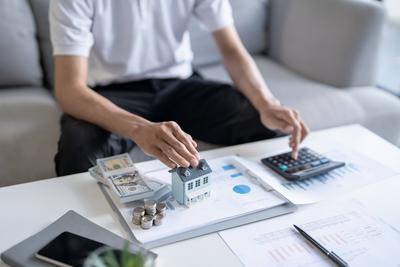 Geld sparen. Mann berechnen Finanzen nach Hause zahlen Rechnungen Steuern Einsparungen Wirtschaft finanzielle zu Hause und Geld stapeln M?nzen mit Taschenrechner sparen-stock-foto