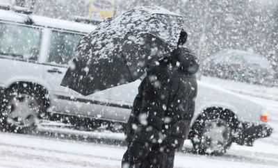 Wintereinbruch in Hamburg. Am Freitagvormittag gab es phasenweise heftigen Schneefall in der Hansestadt. Eine Frau steht-stock-foto
