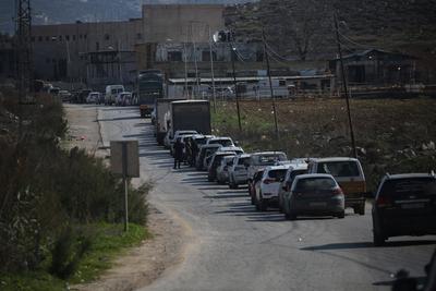 Palestinians wait at a checkpoint southwest of the West Bank city of Nablus, after a shooting attack-stock-foto