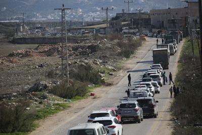 Palestinians wait at a checkpoint southwest of the West Bank city of Nablus, after a shooting attack-stock-foto
