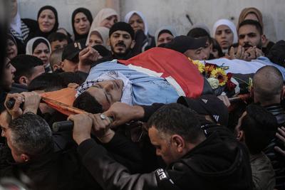 Palestinians carry the body of Moataz al-Madani, 16, who was killed during clashes with Israeli occupation forces, in Askar camp east of the West Bank city of Nablus-stock-photo