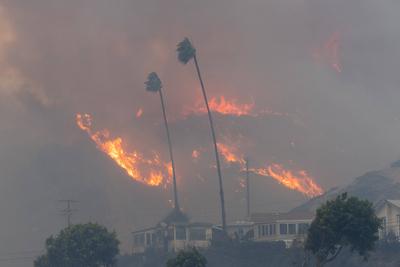 PACIFIC PALISADES, CA - JANUARY 07: Flames from a brush fire pushed by gusting Santa Ana winds approach homes on January-stock-foto
