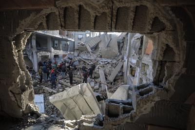 Palestinians check the site of a destroyed house after an Israeli bombardment, in the Al-Bureij refugee camp in central Gaza Strip-stock-photo