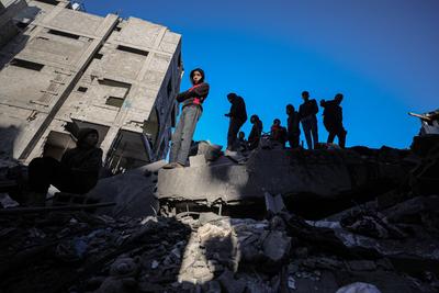 Palestinians check the site of a destroyed house after an Israeli bombardment, in the Al-Bureij refugee camp in central Gaza Strip-stock-photo