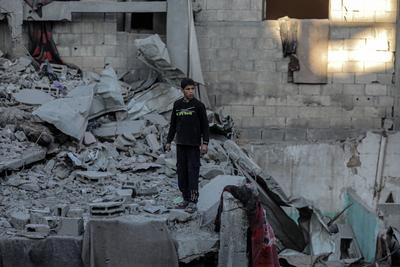 Palestinians check the site of a destroyed house after an Israeli bombardment, in the Al-Bureij refugee camp in central Gaza Strip-stock-photo