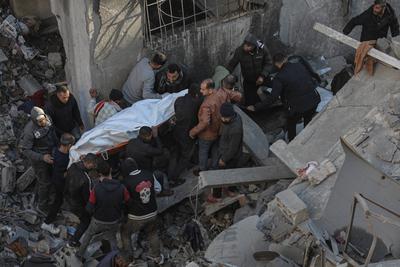 Palestinians check the site of a destroyed house after an Israeli bombardment, in the Al-Bureij refugee camp in central Gaza Strip-stock-photo