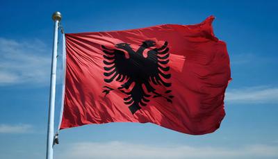 FOTOMONTAGE Fahne, die Nationalfahne von Albanien flattert im Wind-stock-photo