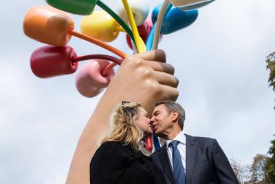 US artist Jeff Koons kisses his wife Justine Wheller Koons as they pose next to the sculpture Bouquet of Tulips, after-stock-photo