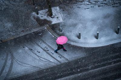 Berlin, Deutschland, Person mit Regenschirm geht an einem verschneiten Wintertag die Strasse entlang-stock-photo
