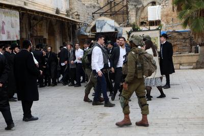 Israeli settlers escorted by Israeli forces participate in a provocative tour in Hebron-stock-foto
