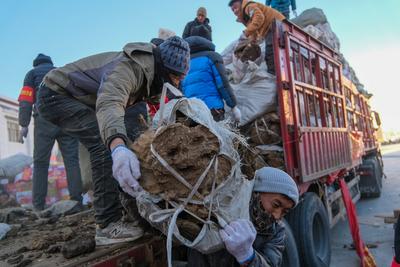 DINGRI, CHINA - JANUARY 10: People unload disaster relief supplies at a relocation site in a village on January 10, 2025-stock-foto