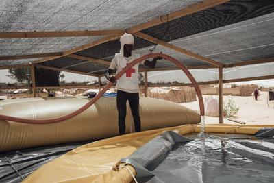  Sudanese refugees in Chad - 19/06/2024 - chad / ? Adre ? - A member of the Chadian Red Cross fills a water tank at an-stock-foto