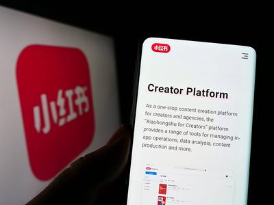 Person holding cellphone with webpage of Chinese social media company Xiaohongshu on screen. Stuttgart, Germany - 07-30--stock-photo
