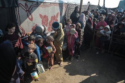 Palestinians gather to receive food cooked by a charity kitchen, before a ceasefire between Hamas and Israel takes effect, in Khan Younis-stock-foto