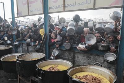 Palestinians gather to receive food cooked by a charity kitchen, before a ceasefire between Hamas and Israel takes effect, in Khan Younis-stock-foto