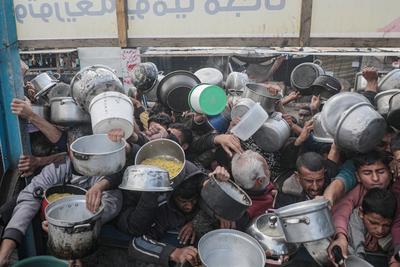 Palestinians gather to receive food cooked by a charity kitchen, before a ceasefire between Hamas and Israel takes effect, in Khan Younis-stock-foto