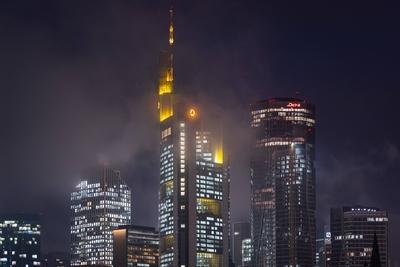 Die Frankfurter Skyline am Abend Tiefe Wolken umh?llen die leuchtenden T?rme der Frankfurter Bankenskyline am Abend. Fra-stock-foto