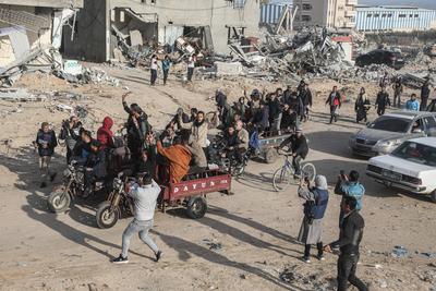 Displaced Palestinians travel in vehicles past rubble, as they attempt to return to their homes, in Rafah-stock-foto
