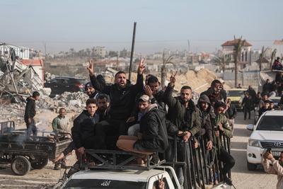 Displaced Palestinians travel in vehicles past rubble, as they attempt to return to their homes, in Rafah-stock-foto