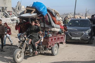 Displaced Palestinians travel in vehicles past rubble, as they attempt to return to their homes, in Rafah-stock-foto
