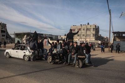 Displaced Palestinians travel in vehicles past rubble, as they attempt to return to their homes, in Rafah-stock-foto